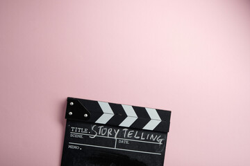story telling textr on clapper borad against pink background