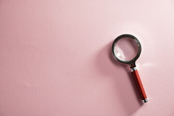 magnifying glass against pink background
