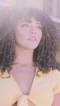 Beauty Afro American woman looking at the horizon. Pretty woman with curly hair feeling peaceful. Cute black female enjoying fresh air thinking about life, optimistic. Vertical video.