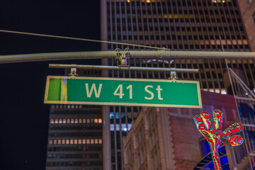 Beautiful night city view of tops of buildings and West 41st Street sign. New York. USA.