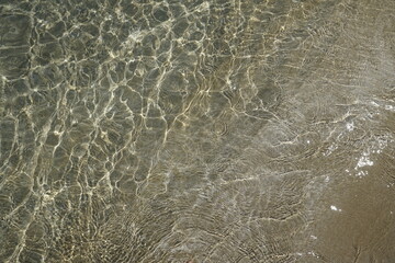 Sun glare on the surface of the water. Sea breeze and beach. Top down view
