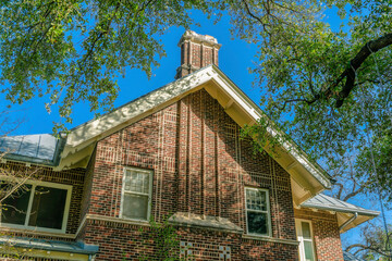 Exterior view of a house with red brick wall and gable roof in San Antonio Texas