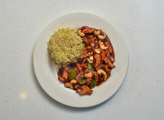 chicken cashew nuts with sauce and fried rice served in a dish isolated on grey background top view of indian, pakistani food