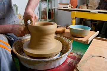 Man professional potter making pottery in his pottery workshop