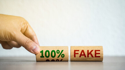 Hand puts blocks with the words 100% fake. Fake news and false information, misleading. Misinformation. Business concept