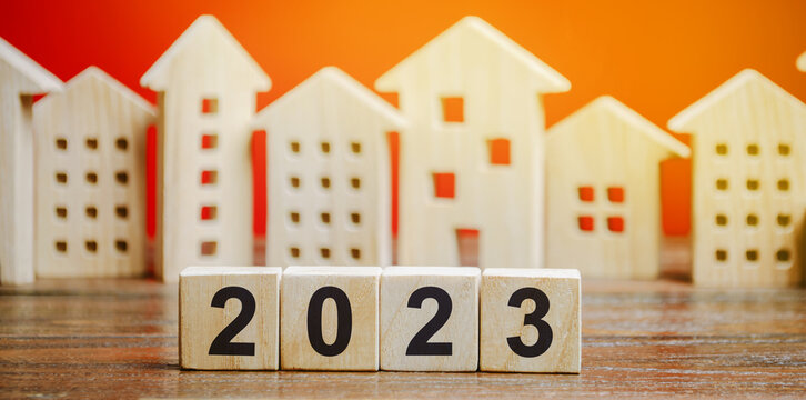 Wooden blocks 2022 and houses. Family budget planning for next year. Investments, plans, savings. Mortgage rates. Real estate concept. Refinance home.