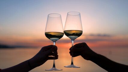 Hands making cheers with wine in glass against the sea - Powered by Adobe