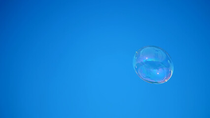 close-up. a big soap bubble flies against the blue sky. High quality photo