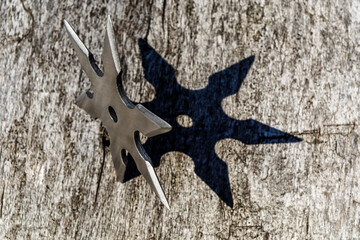 Shuriken (throwing star), traditional japanese ninja cold weapon stuck in wooden background,Silver...