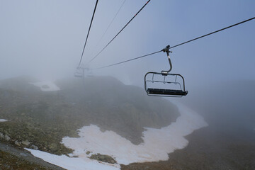 Empty ski lift seats in the fog at L'Index,  Aiguille Rouges , La Flegere, Chamonix, French Alps, Rhone Alpes, France. 