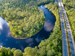 East Bay River flowing along the lush forest and roads in Navarre Florida