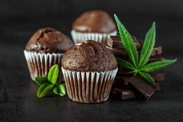 Cupcake with marijuana.traditional sponge cake with cannabis weed cbd. Medical marijuana drugs in food dessert, ganja legalization.Stack of chocolate slices with mint leaf on a wooden table.