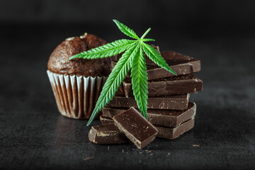 Cupcake with marijuana.traditional sponge cake with cannabis weed cbd. Medical marijuana drugs in food dessert, ganja legalization.Stack of chocolate slices with mint leaf on a wooden table.