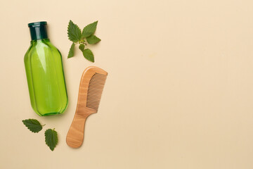 Fototapeta na wymiar Shampoo with nettle extract on color background, top view