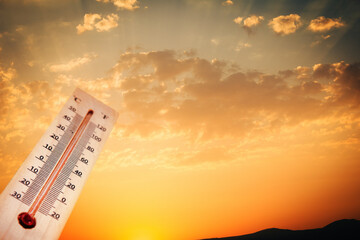 hot temperature, thermometer on yellow sky with shining summer sun