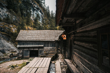 Fototapeta na wymiar Beautiful old wooden cabin deep in the forest - Mlyny Oblazy (Slovakia). Old wooden mill with rocks on background in autumn time.