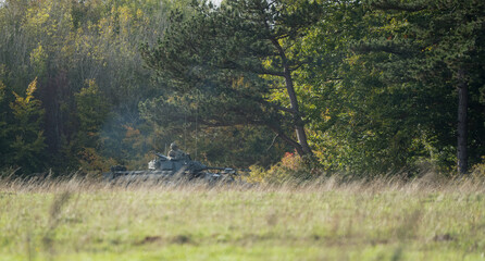 British army FV510 Warrior Fighting Vehicle manoeuvres through woodland on a military exercise, Wiltshire UK