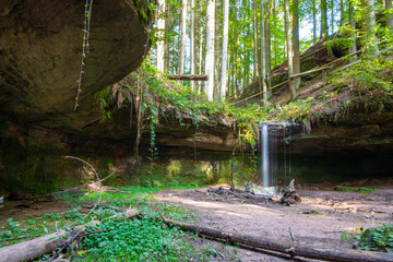 natürlicher Wasserfall mit Felsen und grünen Moos im Pfälzer Wald in Deutschland