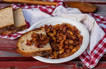 fried goose cracklings on a white plate table.