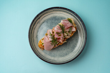 bruschetta with ham on a plate on a colored background