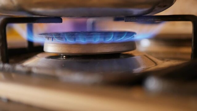 the turned on burner of the gas stove burns with a blue fire close-up and the fire goes out. Gasification of residential premises for domestic needs. Gas situation in the world