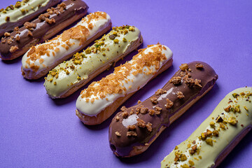 Assorted eclairs on a colored background