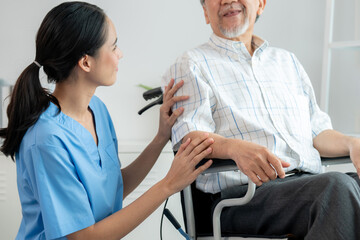Happy positive asian nurse giving support and touching contented senior man with love. Nursing home...