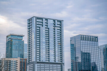 Naklejka premium Buildings with reflective glass windows in downtown Austin Texas on a cloudy day