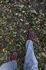 Men's hiking boots on a leaf covered trail in the autumn woodlands of Wisconsin.