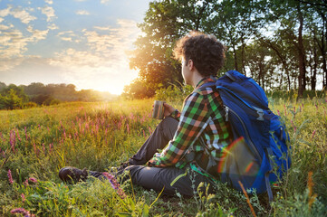 Young hiker having rest at the sundown