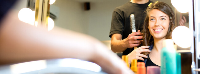 Young woman getting new hairstyle from hairdresser in the modern hair salon