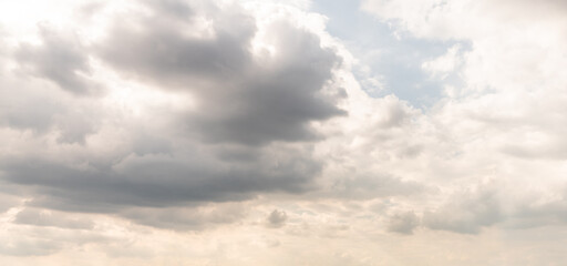 Gray gloomy clouds with occasional gaps in the rays of the sun