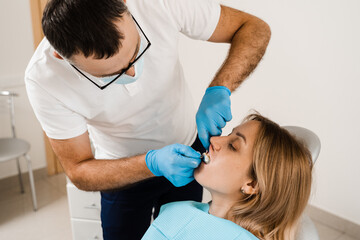 Doctor inserts impression tray and making cast of teeth to patient in dentistry before dental...