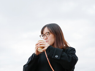 Beautiful Japanese woman drinking a hot coffee outside - 540135228