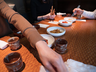 Hands picking at side dishes in a Korean restaurant - 540136010