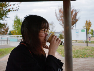 A beautiful Japanese lady drinking coffee in a park - 540136286