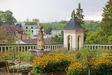 Fototapeta na wymiar Garden with fountain and small pavilion in front of new buildings and powerlines
