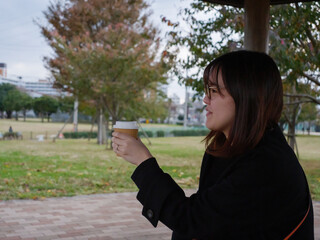 A beautiful Japanese lady drinking coffee in a park - 540137005