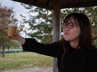 A beautiful Japanese lady drinking coffee in a park - 540137046