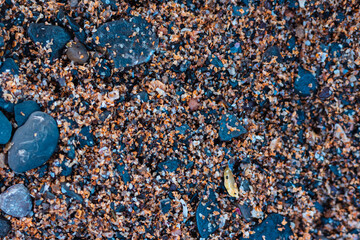 Piedras negras sobre una arena gruesa