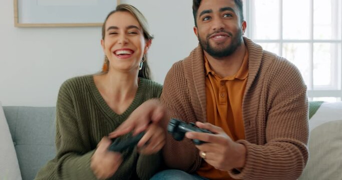 Fun, playing and love with a gamer couple laughing, joking or bonding while gaming on a sofa in the living room of their home together. Game, funny and laugh with a man and woman enjoying video games