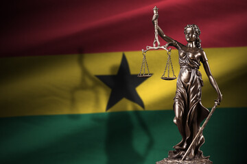Ghana flag with statue of lady justice and judicial scales in dark room. Concept of judgement and...