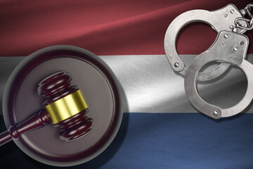 Netherlands flag with judge mallet and handcuffs in dark room. Concept of criminal and punishment,...