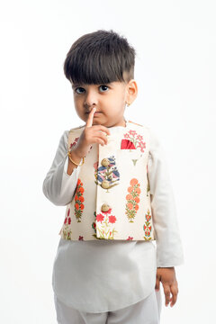 Cute Indian Little Child In Ethnic Wear And Showing Expression Over White Background