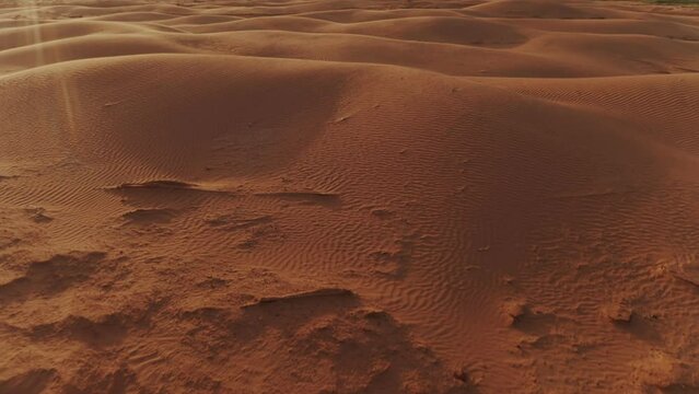 flying over the dunes in the desert at sunset, glare from the sun