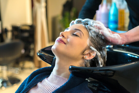 Hairdresser washing hair of the woman in modern hair salon