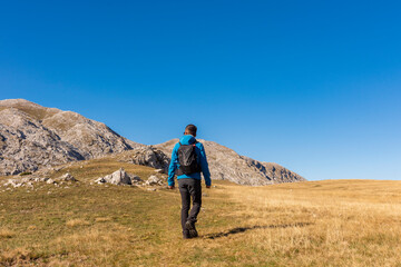A man walks to the path head to the rocky peak.