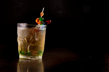 creepy halloween drink in skull cup and jellied candy worm garnishes