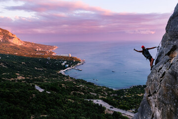 Man in helmet climbing on a rock. Rock climber training