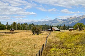 Panoramic photo of barn and mountains.